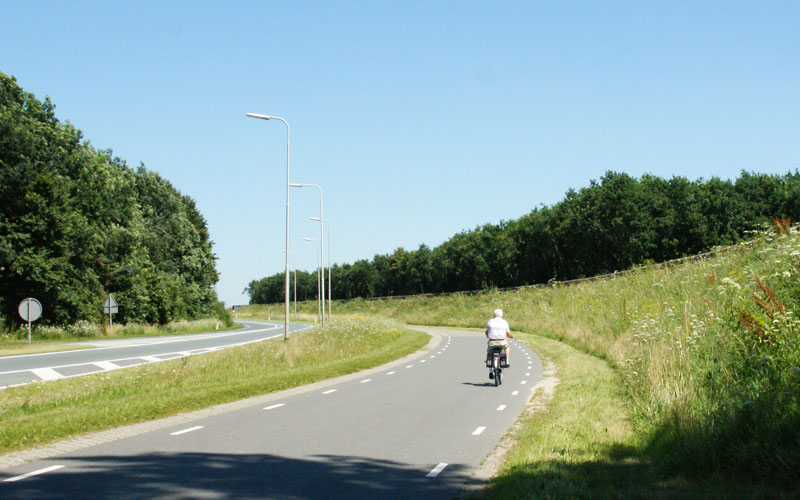 fietser op parallelweg langs geluidswal